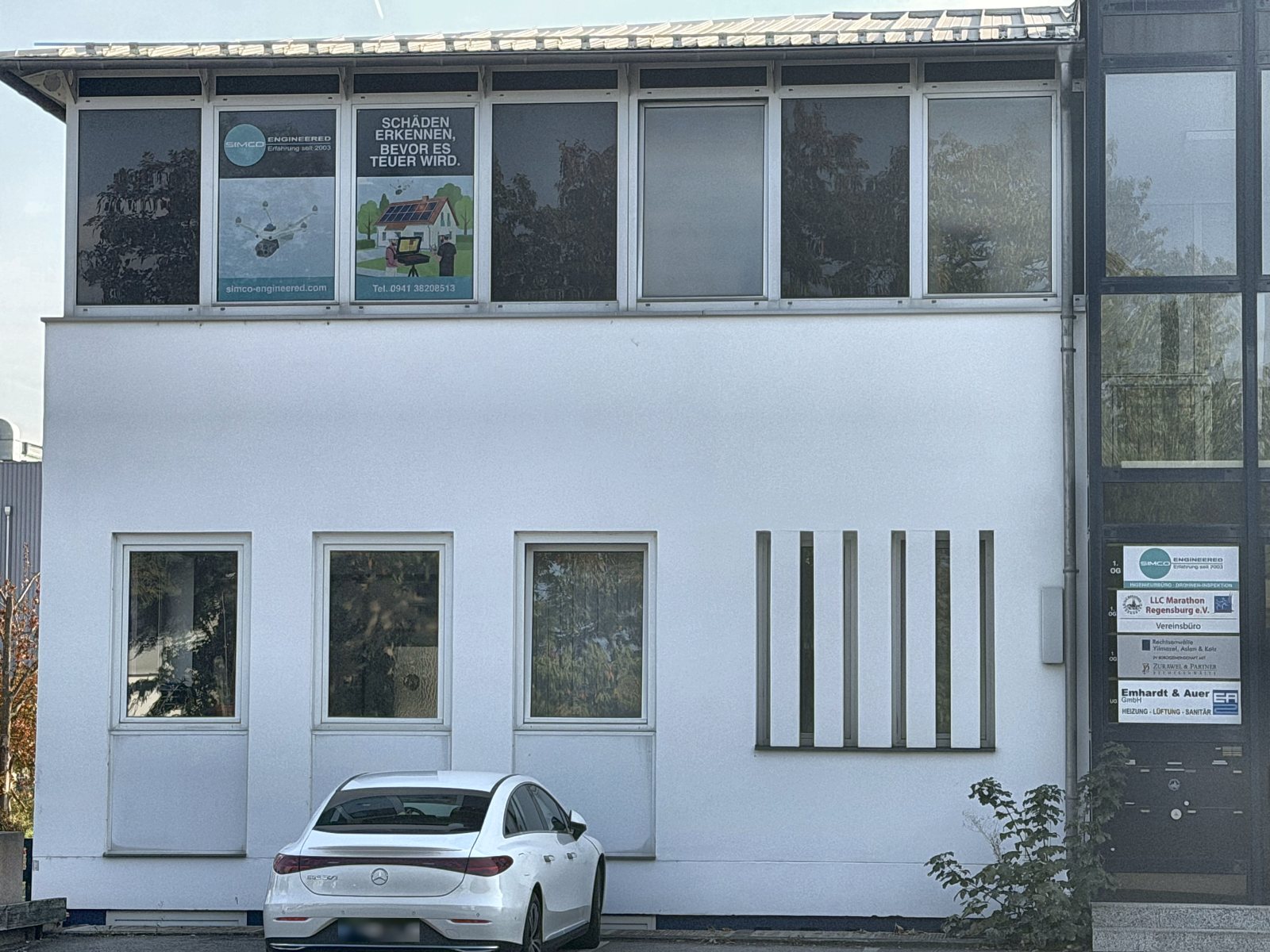 Fassade mit SimCo-B&uuml;ro im 1. Obergeschoss und SimCo-Schild am Eingang