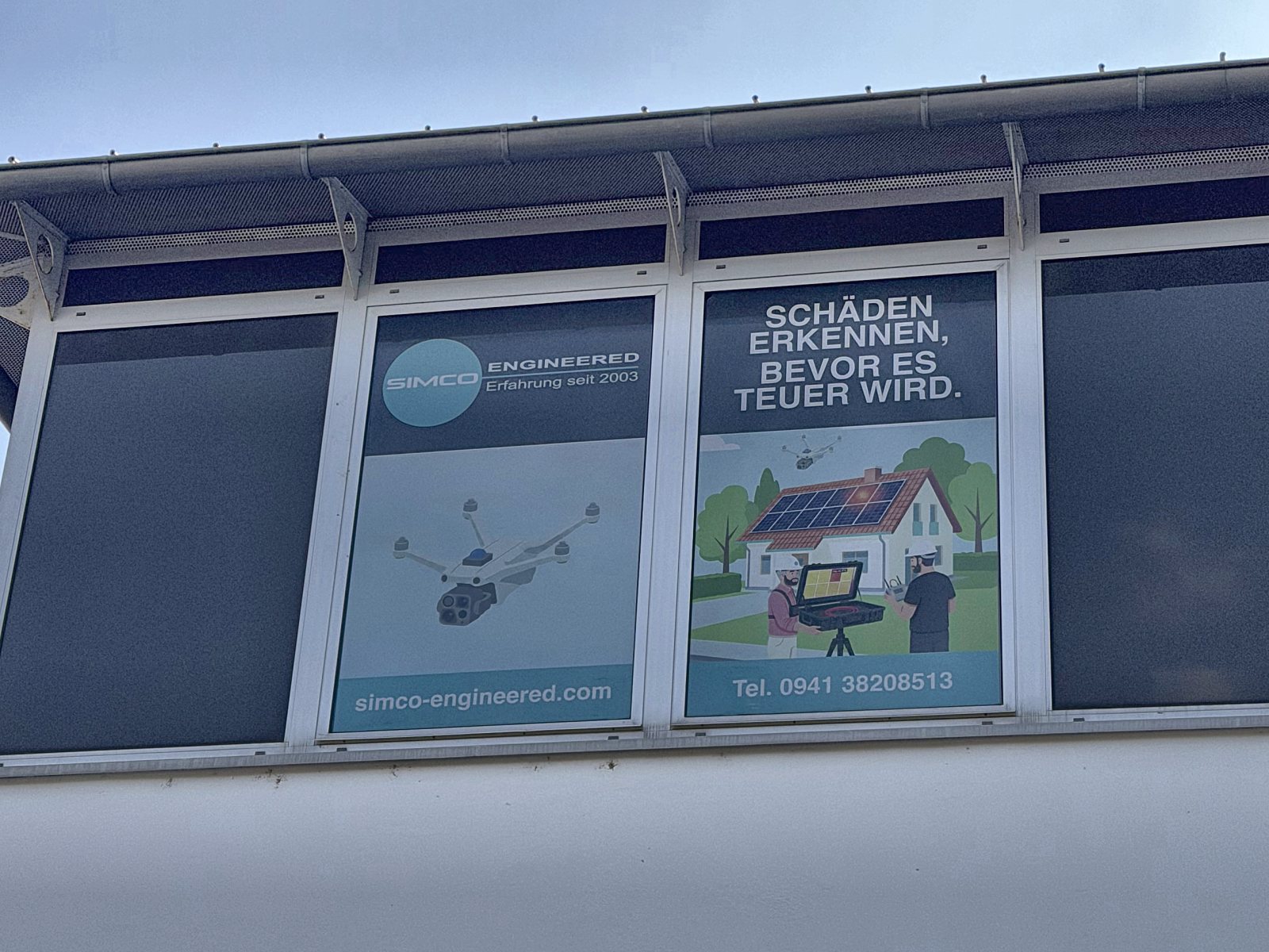 SimCo-Fensterfolien am B&uuml;ro: Drohne und Slogan Sch&auml;den erkennen, bevor es teuer wird